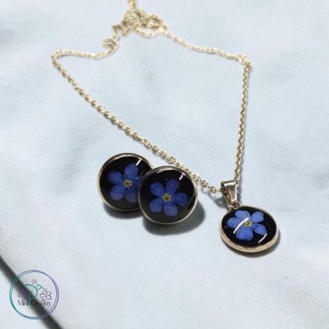 Delikatny komplet biżuterii z niezapominajkami na czarnym tle