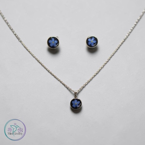 Delikatny komplet biżuterii z niezapominajkami na czarnym tle