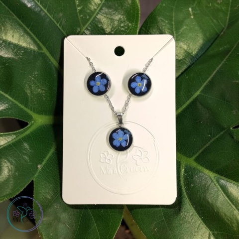 Delikatny komplet biżuterii z niezapominajkami na czarnym tle