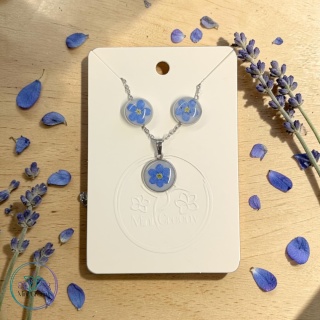 Delikatny komplet biżuterii z niezapominajkami na mlecznym tle