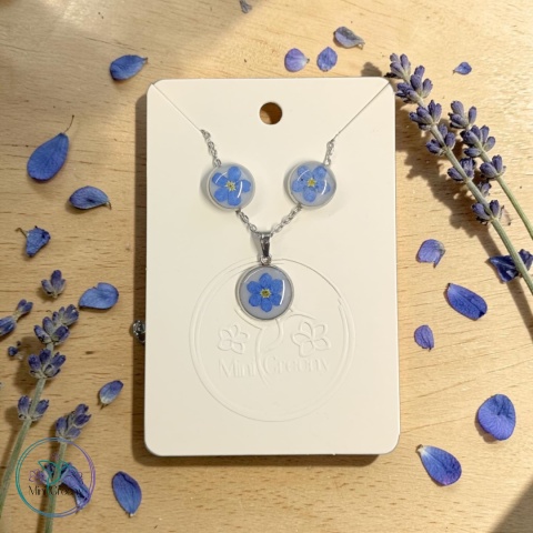 Delikatny komplet biżuterii z niezapominajkami na mlecznym tle