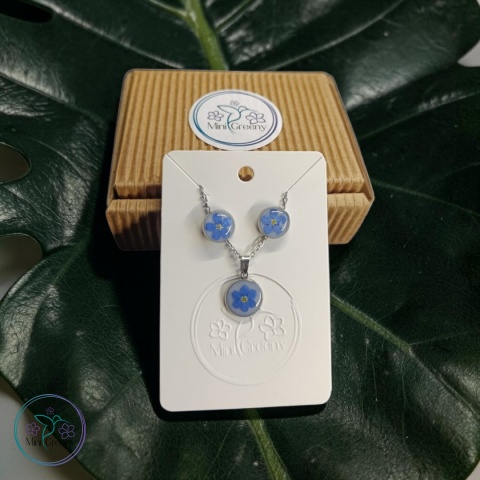 Delikatny komplet biżuterii z niezapominajkami na mlecznym tle