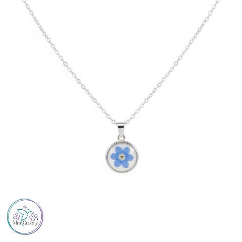 Okrągły wisiorek z niezapominajką na mlecznobiałym tle