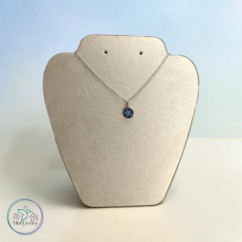 Okrągły wisiorek z niezapominajką na czarnym tle