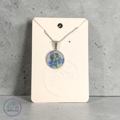 Mały okrągły wisiorek z niezapominajką